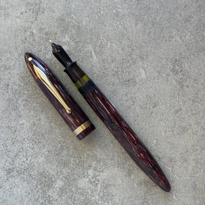 Fountain pen with gold accents on a gray concrete surface