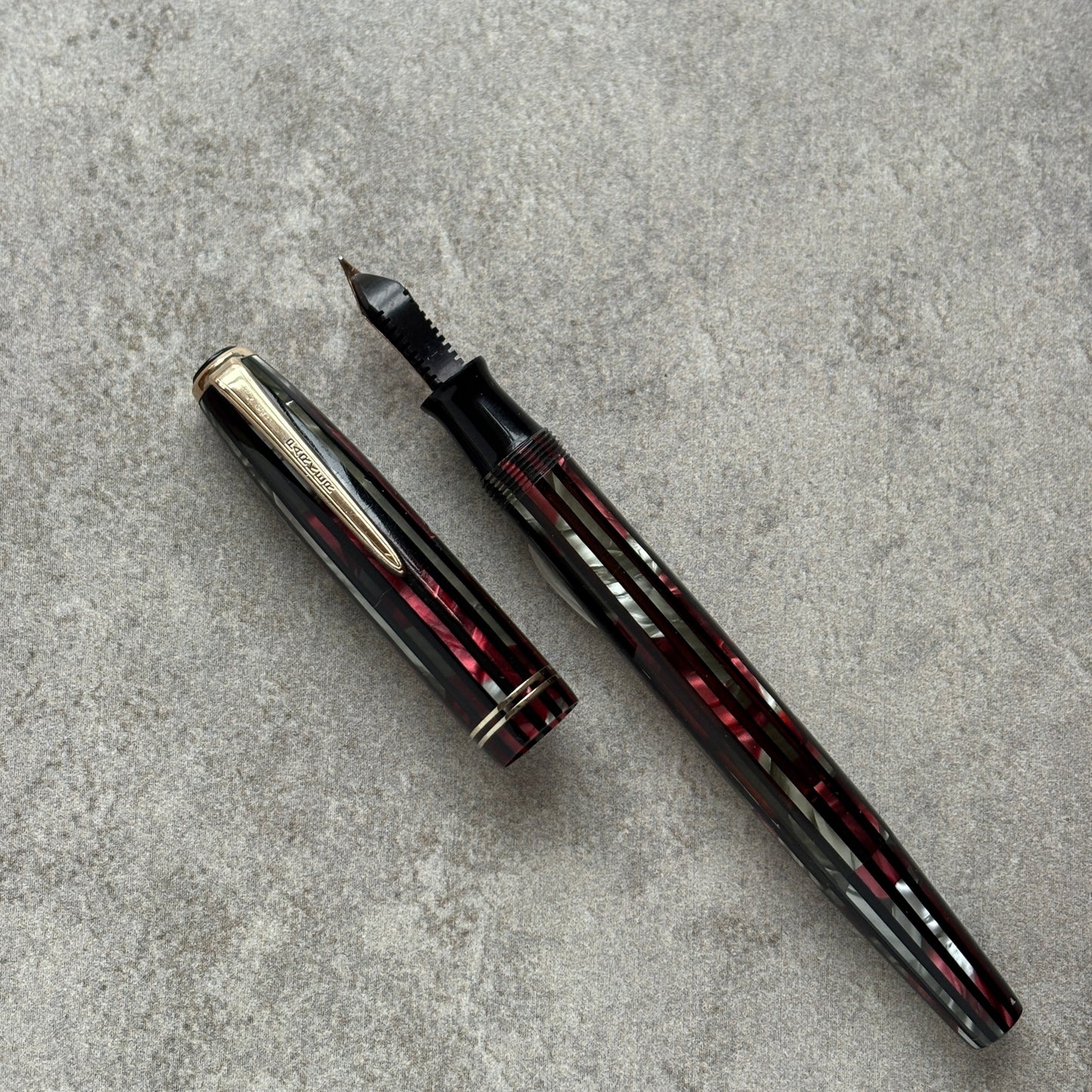 Fountain pen with cap on a gray concrete surface