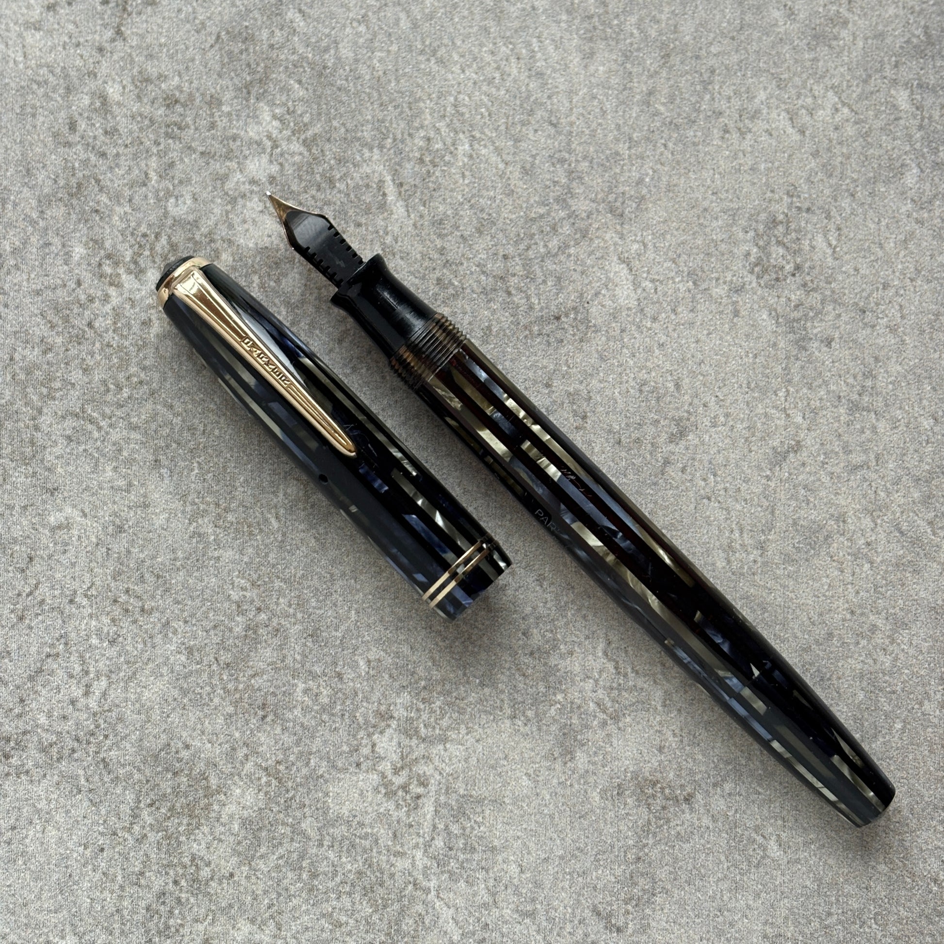 Fountain pen with cap on a gray concrete surface