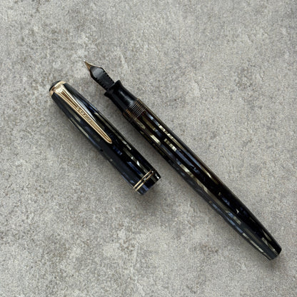 Fountain pen with cap on a gray concrete surface