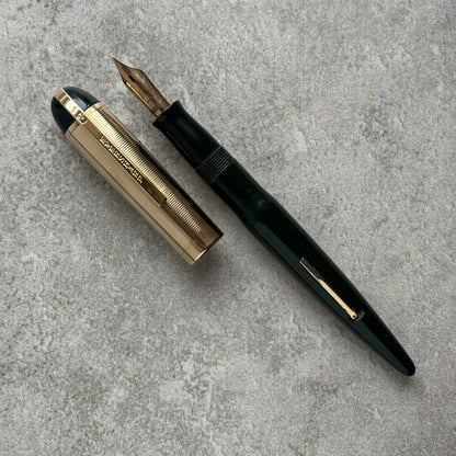 Fountain pen with gold accents on a gray concrete surface