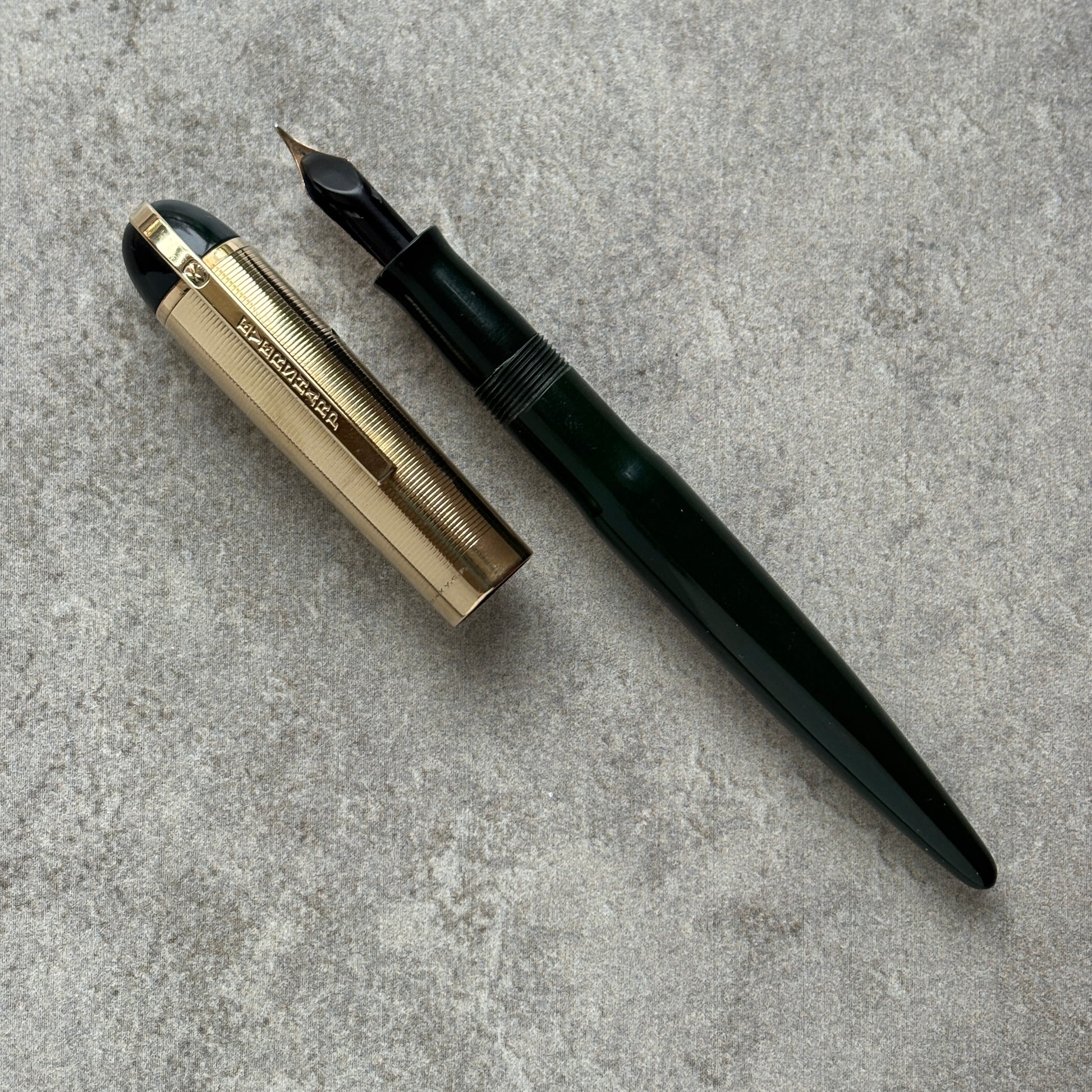 Fountain pen with gold accents on a gray concrete surface