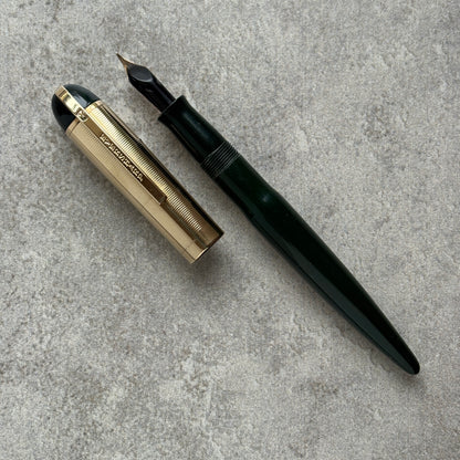 Fountain pen with gold accents on a gray concrete surface
