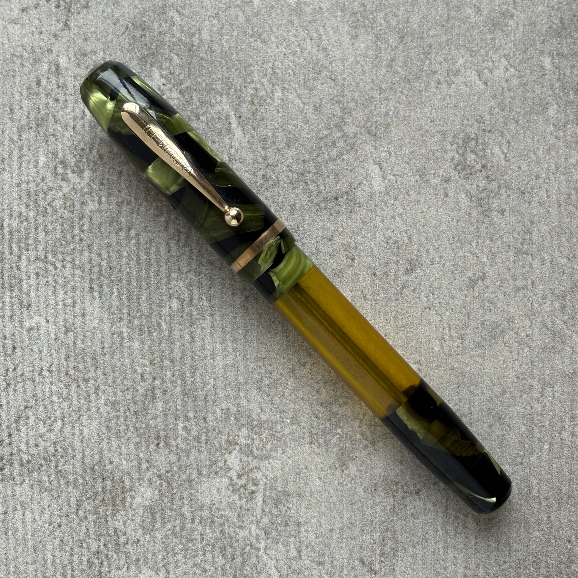Pen with green and black design on a gray surface