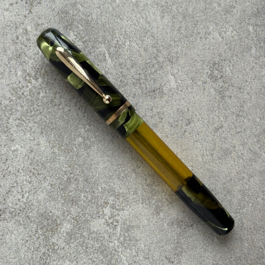 Pen with green and black design on a gray surface
