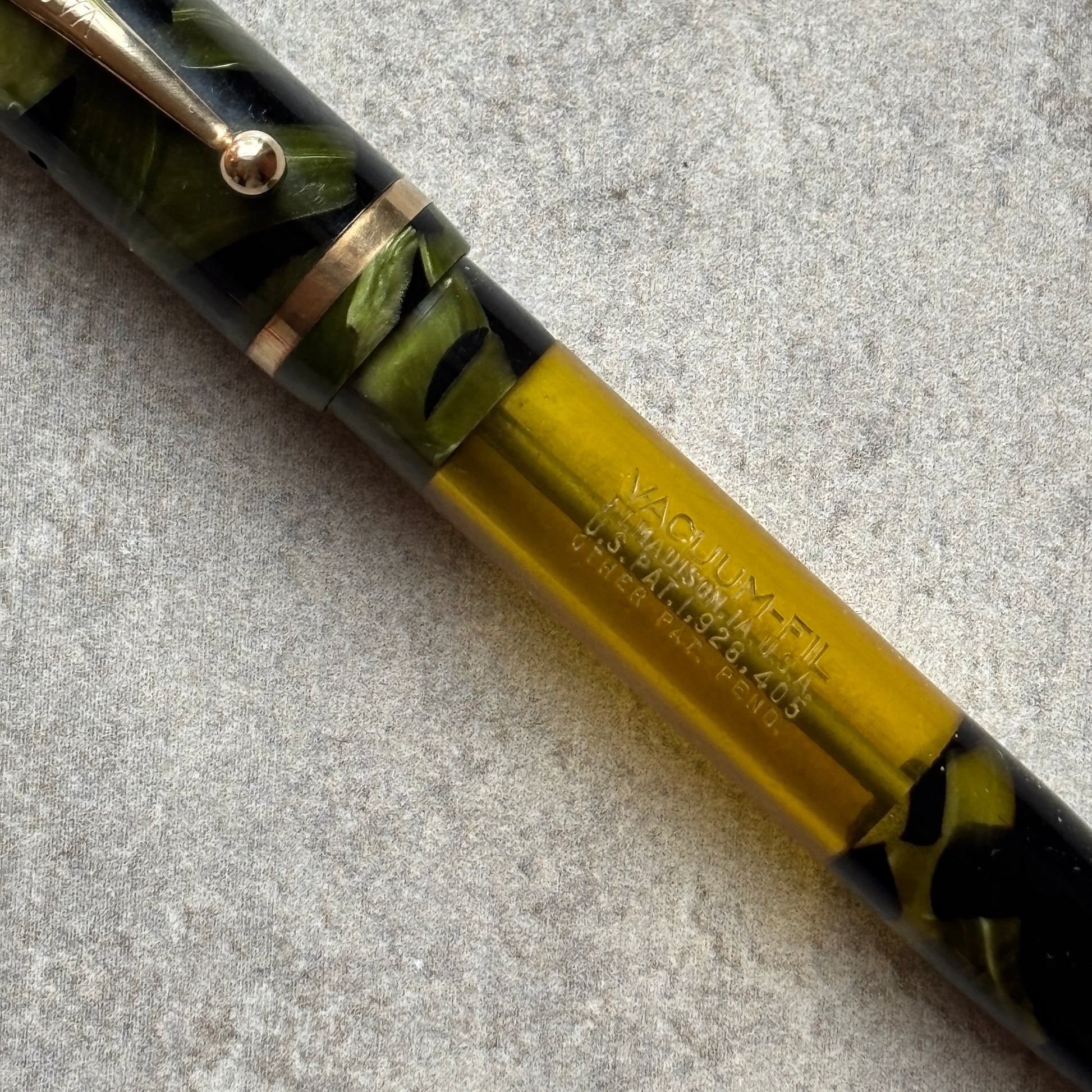 Close-up of a pen with green and black design on a gray surface