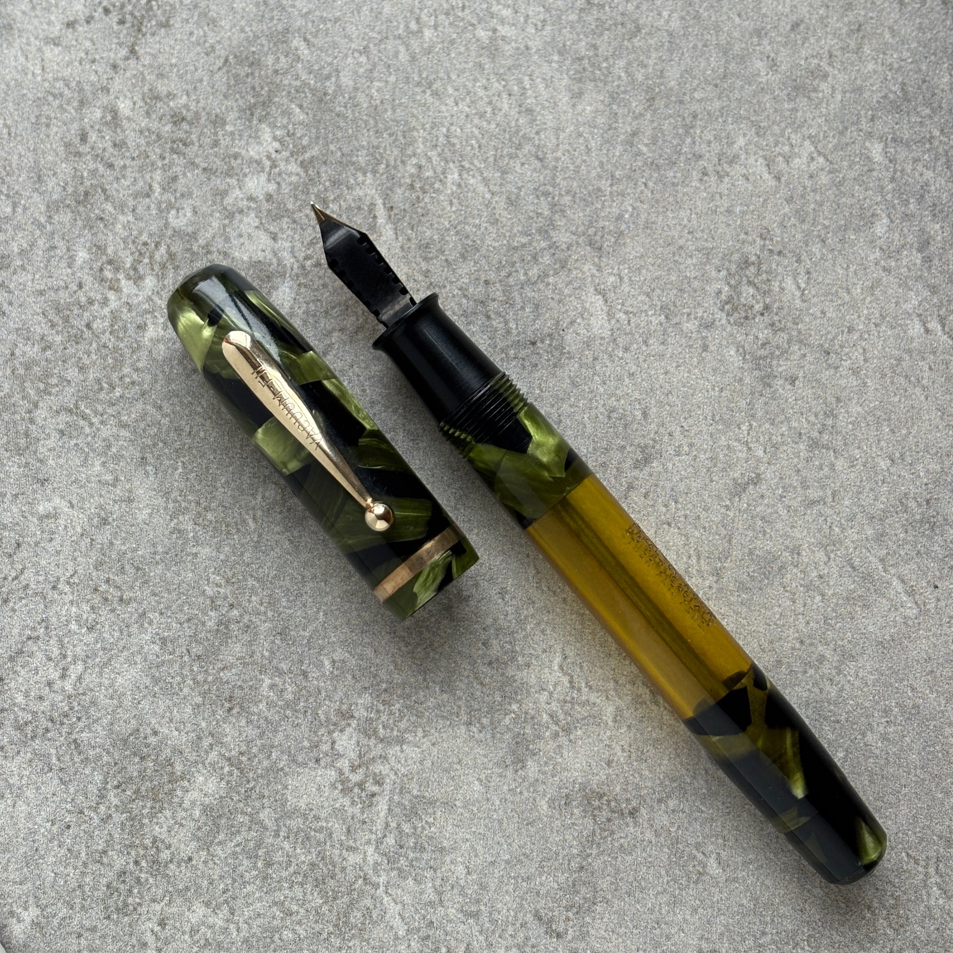 Fountain pen with green and black design on a gray surface