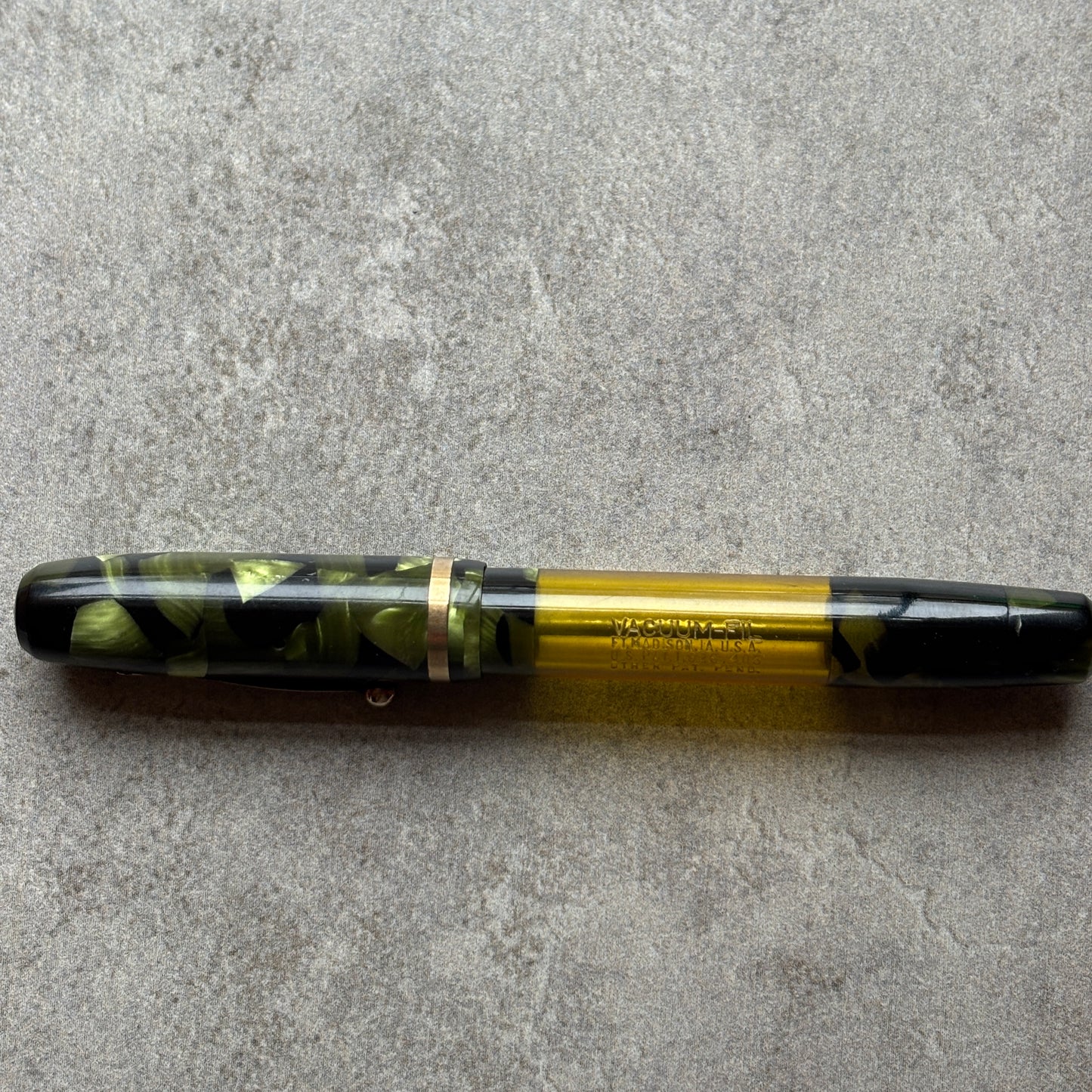 Fountain pen with green and black design on a gray surface