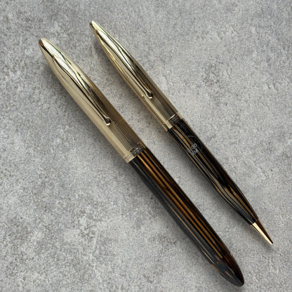  fountain pen and pencil set  on a gray concrete surface.