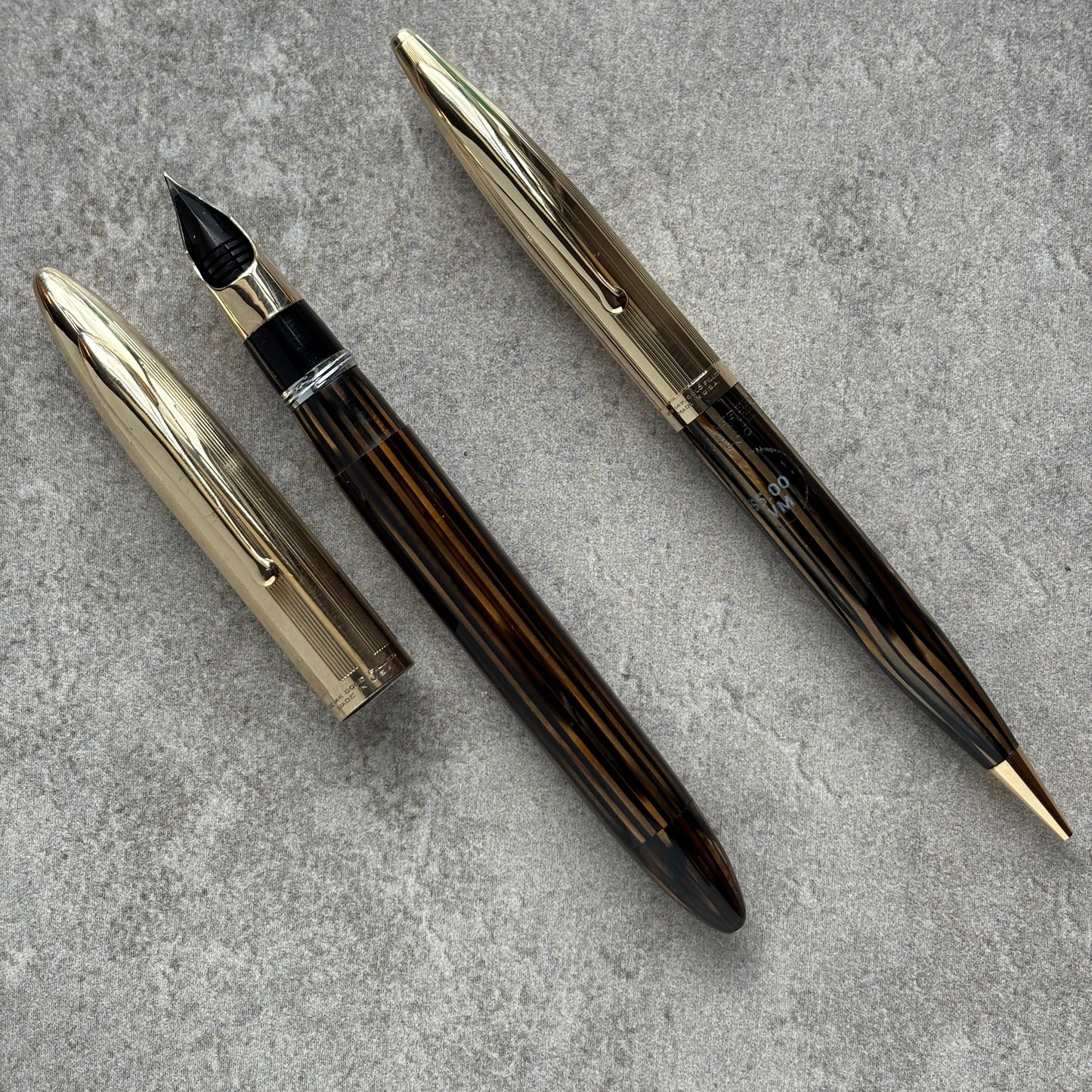 Fountain pen and its components on a gray surface