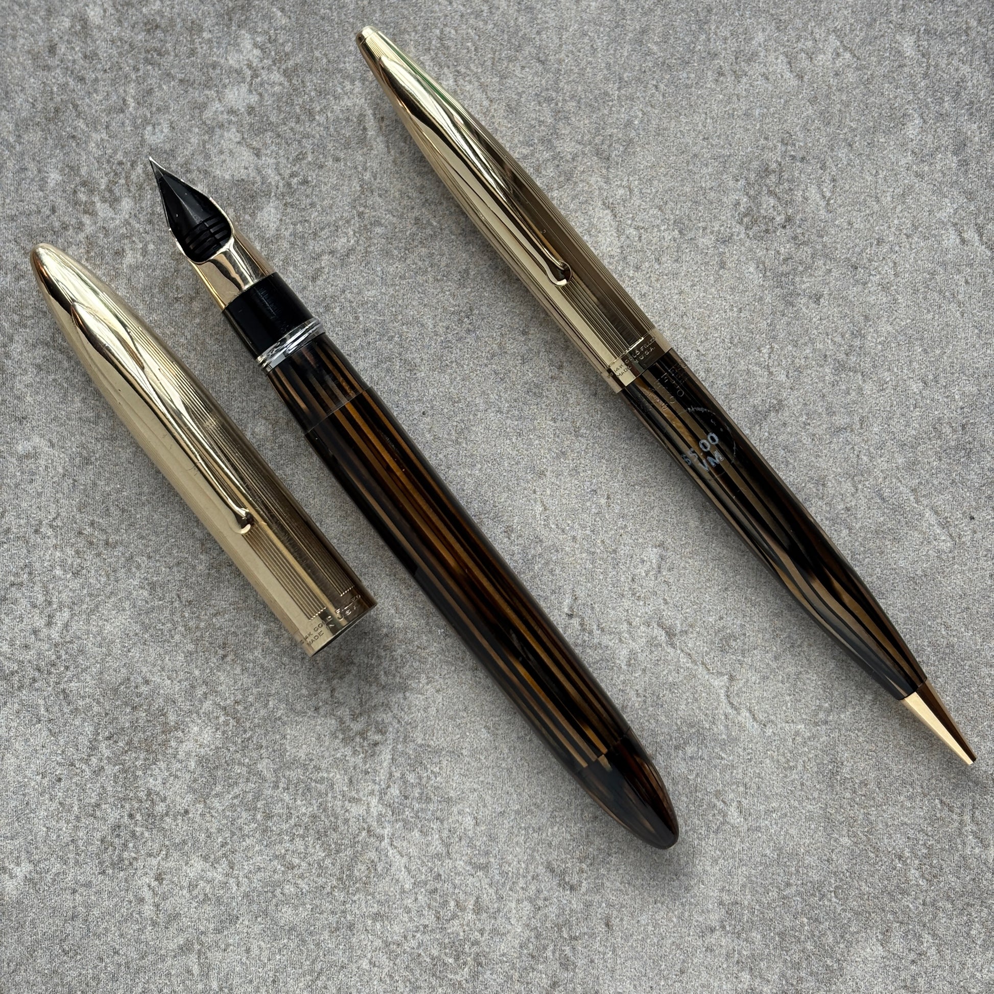 Fountain pen and its components on a gray surface