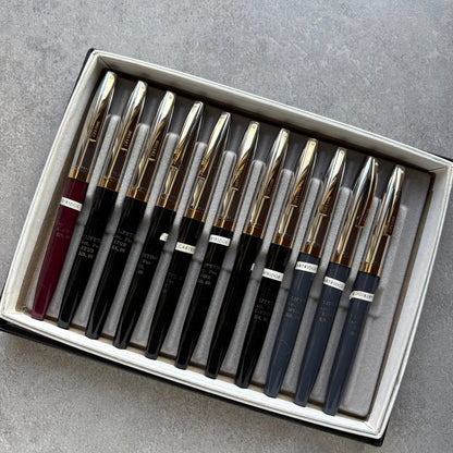 Set of pens with gold accents in a box on a gray surface
