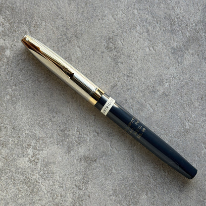 Pen with gold and black design on a gray surface