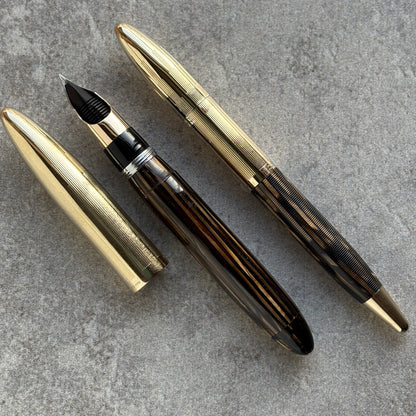 Fountain pen with gold accents on a gray surface