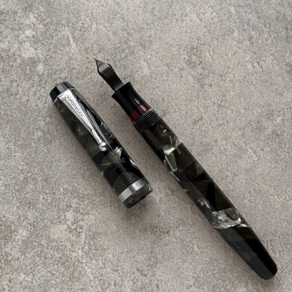 Parker Fountain pen with a transparent grip on a gray surface
