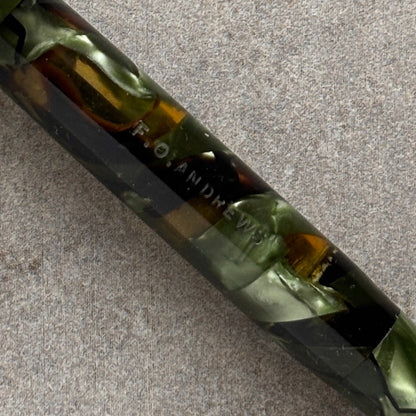 Fountain pen with green and black marbled design on a gray surface