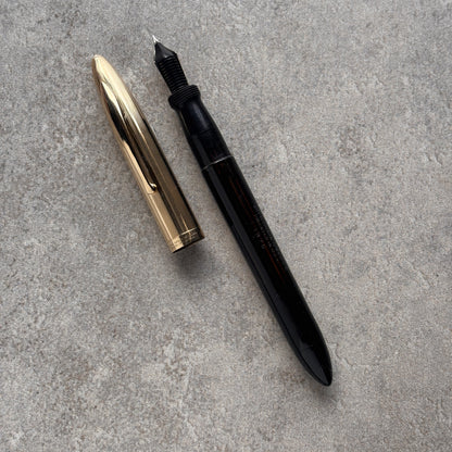 Black and gold fountain pen on a gray surface