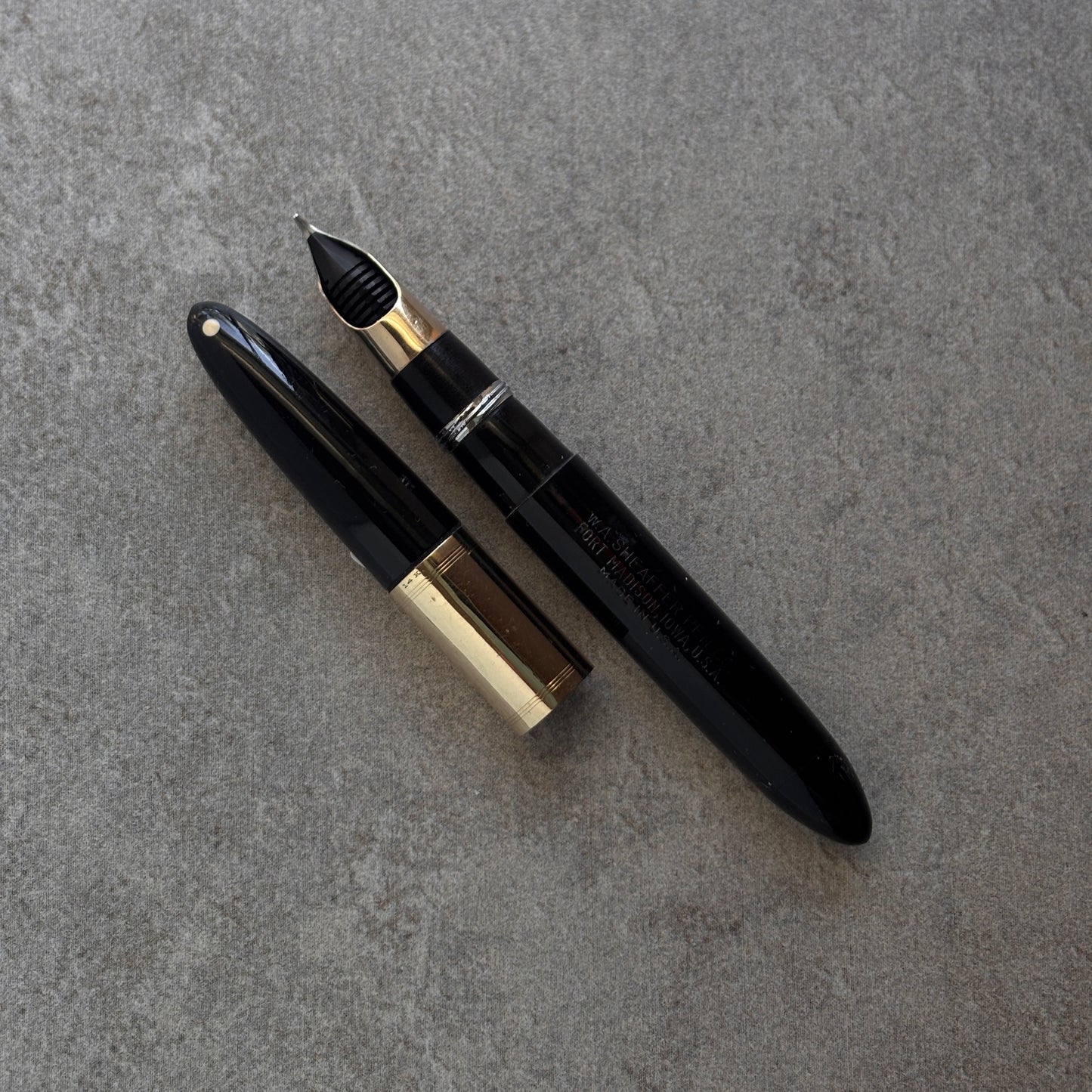 Black and gold fountain pen on a gray surface