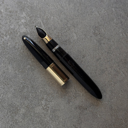Black and gold fountain pen on a gray surface